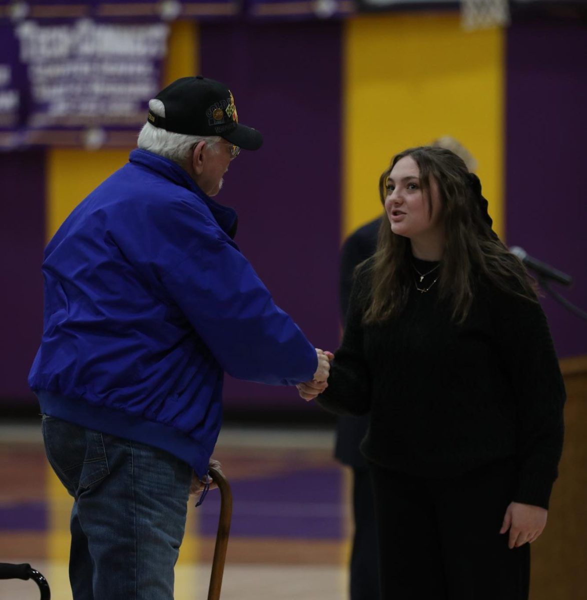 Junior Emilee Burton shakes a veteran's hand.