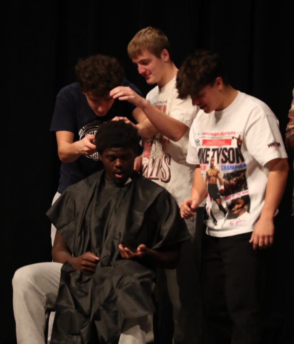 Senior Kirkland Hughes shaves senior Chad Sullivan's head.