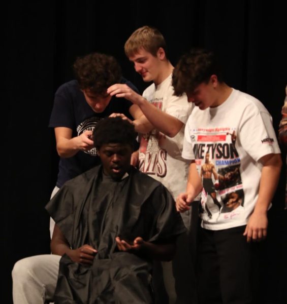 Senior Kirkland Hughes shaves senior Chad Sullivan's head.