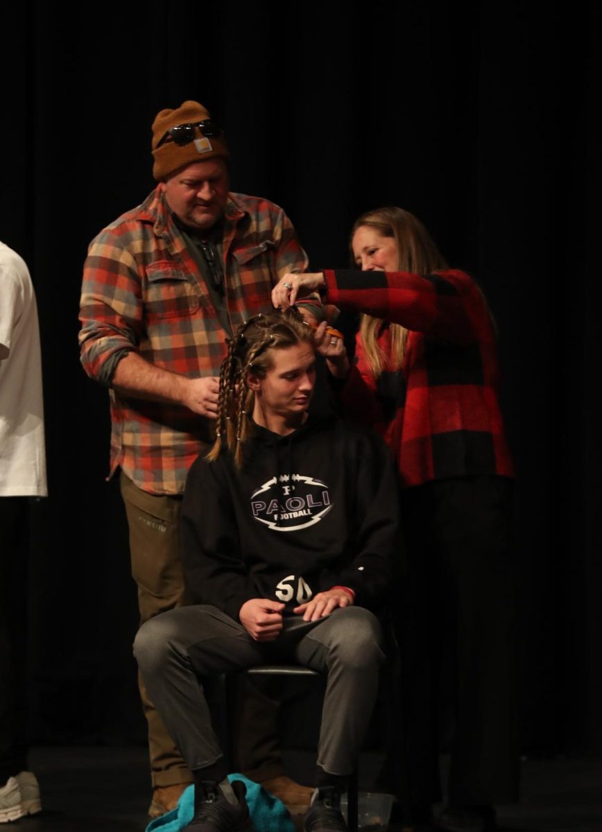 Senior Charlie Higgins gets his hair cut by his mom, Chemistry teacher Melissa Higgins, and his dad Chris Higgins.
