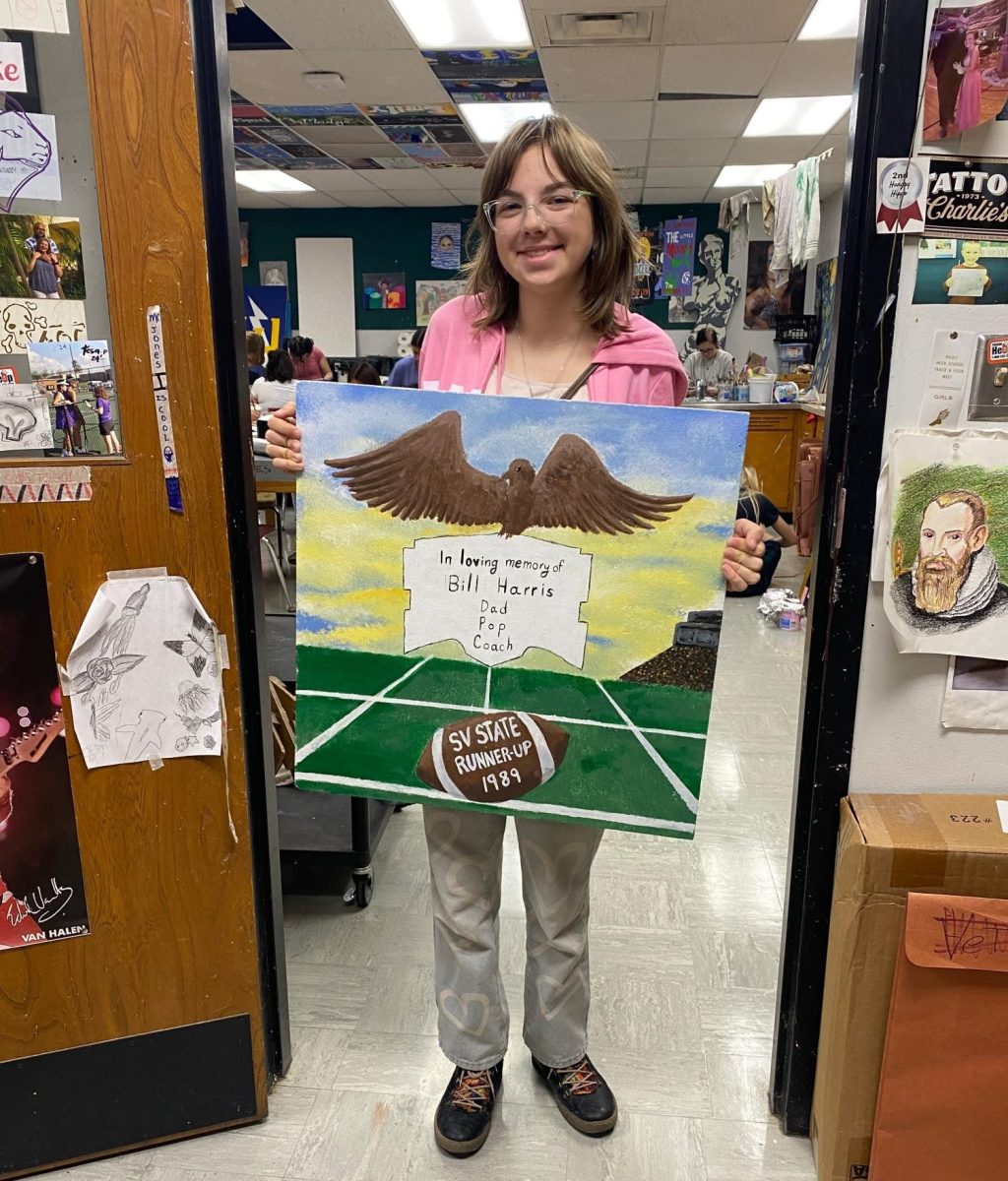 Sophomore Viola Bender poses with the tile she created for Math teacher Kyle Chase.