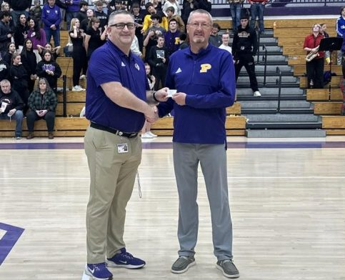 Walker poses with Athletic Director Darek Newkirk after being presented with a lifetime season pass to Rams Athletic Events.