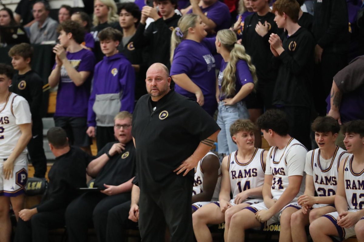 Boys Basketball Coach Dusty Cole watches a play from the sidelines.
