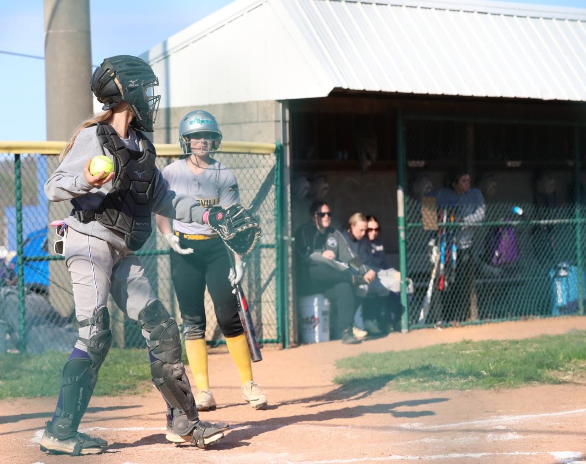 Head Softball Coach Brandy Dillard sits in the dugout during a softball game.