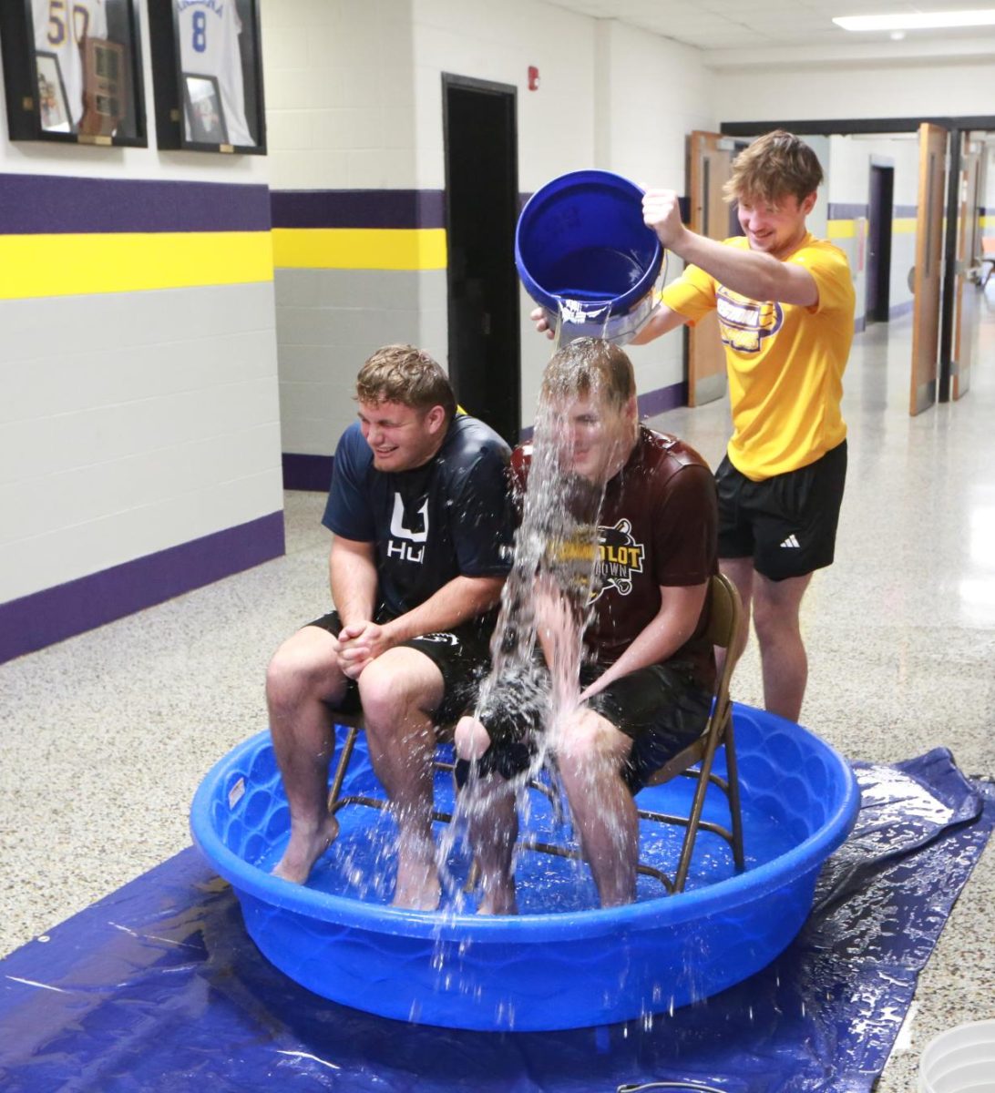 Seniors Kentlee Scholl and Cooper Spires go under the ice bucket by junior Austin Robbins for their homeroom’s booth.